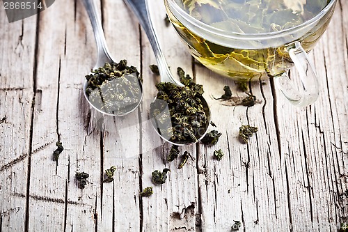 Image of cup of green tea and spoons 