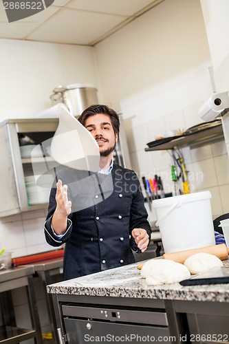 Image of Chef tossing dough while making pastries