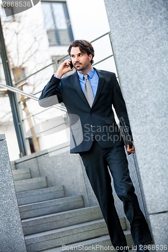 Image of Businessman listening to a call on his mobile