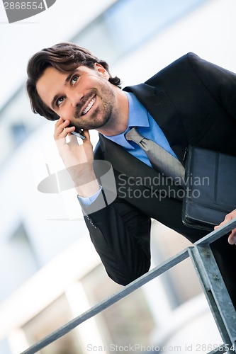 Image of Businessman listening to a call on his mobile