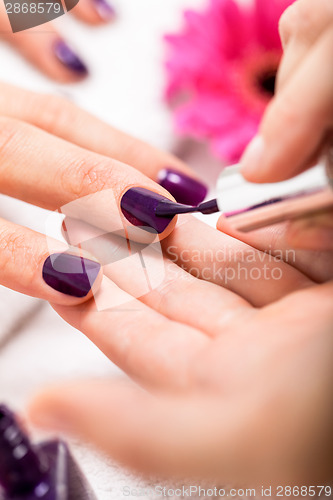 Image of Woman having a nail manicure in a beauty salon