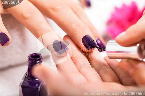 Image of Woman having a nail manicure in a beauty salon