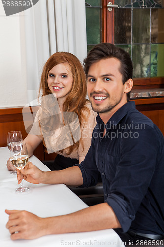 Image of Waiter happily accommodating couple
