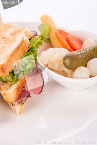 Image of Delicious pastrami club sandwich and pickles