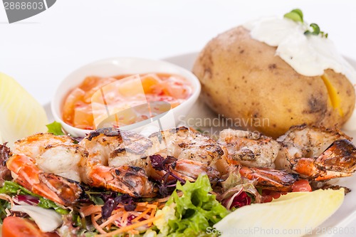 Image of Grilled prawns with endive salad and jacket potato