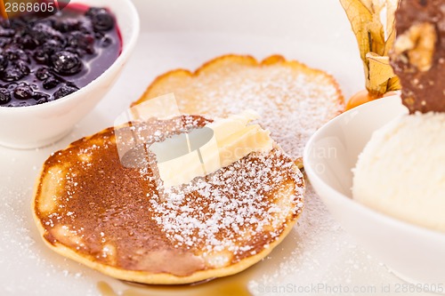 Image of tasty sweet pancakes with vanilla icecream and topping