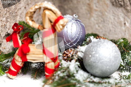 Image of Silver Christmas bauble on a tree with snow