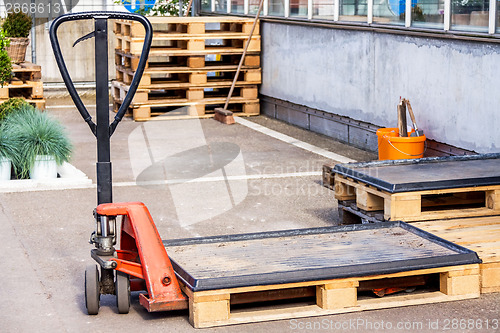 Image of Small orange forklift parked at a warehouse