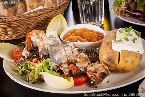 Image of Grilled prawns with endive salad and jacket potato