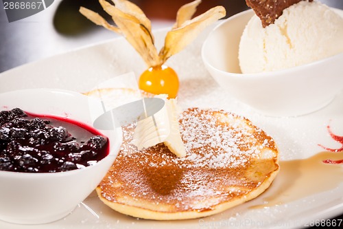 Image of tasty sweet pancakes with vanilla icecream and topping