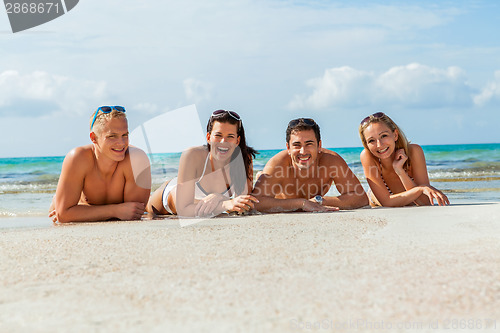 Image of young happy friends havin fun on the beach