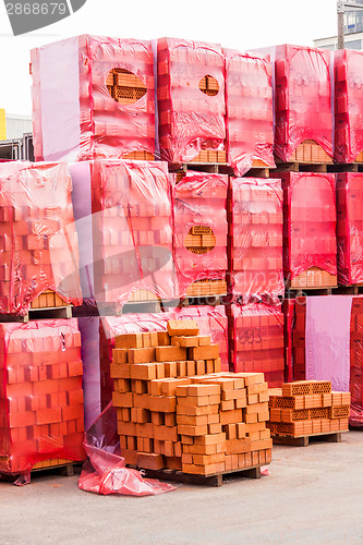 Image of Red clay bricks stacked on pallets