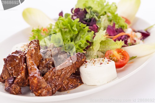 Image of grilled beef stripes fresh salad and goat cheese