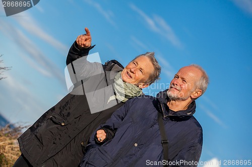 Image of happy elderly senior couple walking on beach