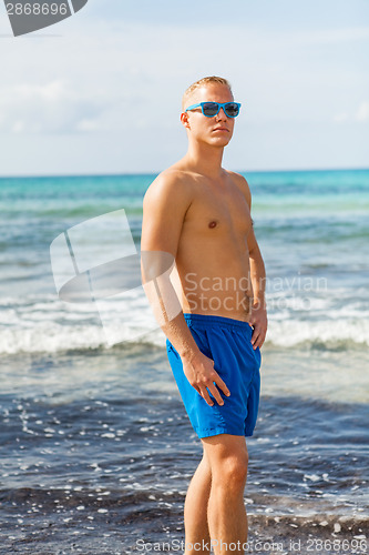 Image of Man in blue swim shorts in the beach