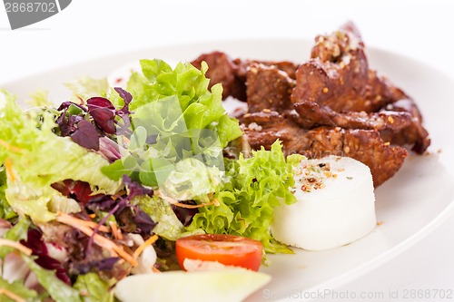 Image of grilled beef stripes fresh salad and goat cheese