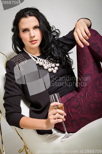 Image of Seductive brunette holding a glass of champagne