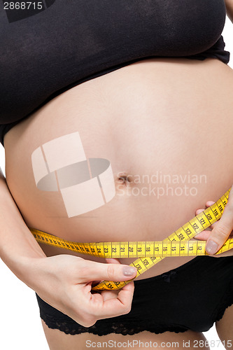 Image of Pregnant woman measuring her abdomen