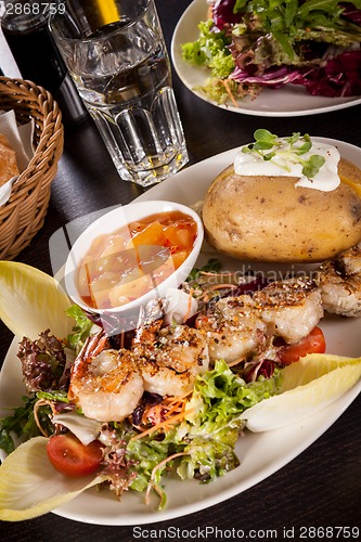 Image of Grilled prawns with endive salad and jacket potato