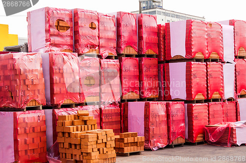 Image of Red clay bricks stacked on pallets