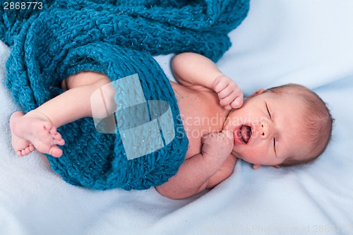 Image of Small infant wrapped in knitted fabric