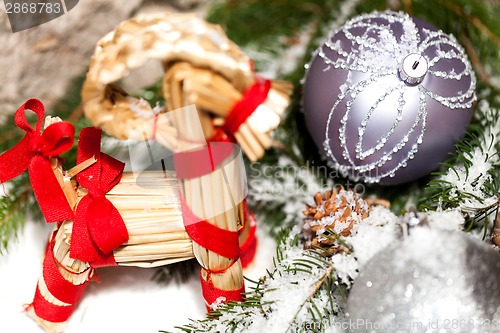 Image of Silver Christmas bauble on a tree with snow