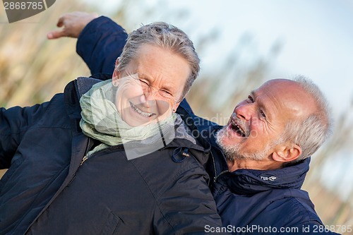 Image of Elderly couple embracing and celebrating the sun