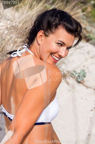 Image of Beautiful woman sitting on golden beach sand