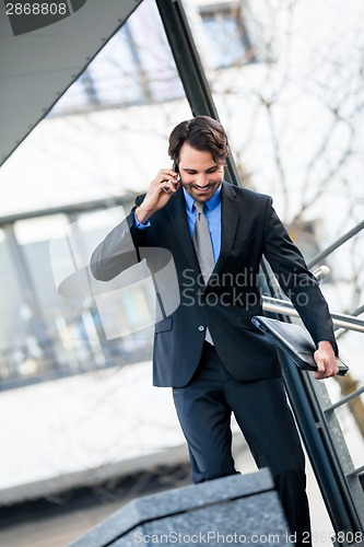 Image of Businessman listening to a call on his mobile