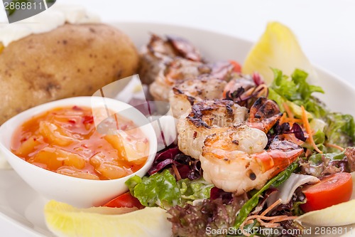 Image of Grilled prawns with endive salad and jacket potato