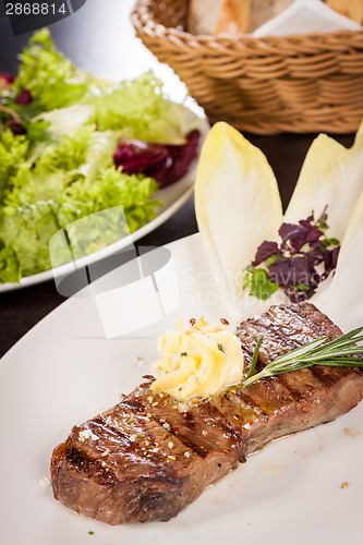 Image of Grilled beef steak topped with butter and rosemary