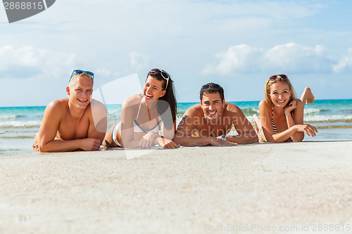 Image of young happy friends havin fun on the beach