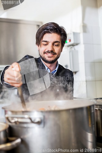 Image of Chef cooking a vegetables stir fry over a hob