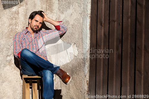 Image of Male model sitting with legs crossed