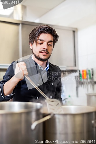 Image of Chef cooking a vegetables stir fry over a hob