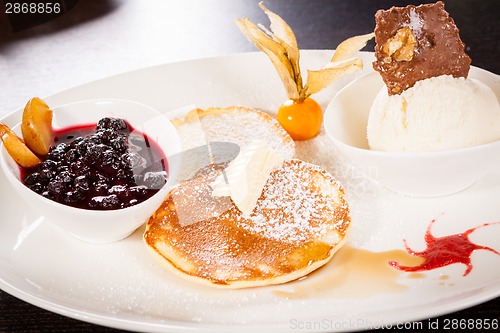 Image of tasty sweet pancakes with vanilla icecream and topping