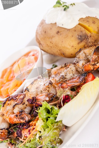 Image of Grilled prawns with endive salad and jacket potato