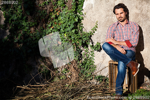 Image of Male model sitting with legs crossed