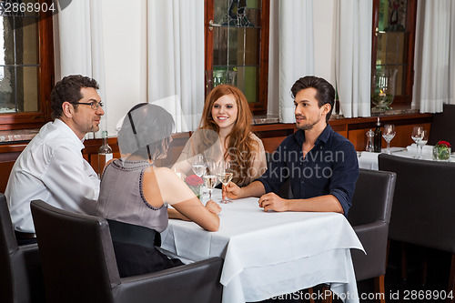 Image of Waiter happily accommodating couple