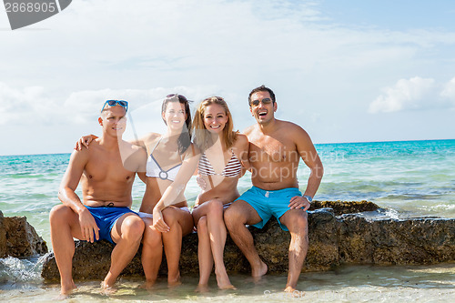 Image of young happy friends havin fun on the beach