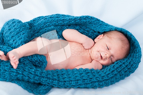 Image of Small infant wrapped in knitted fabric