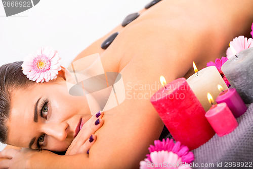 Image of young attractive woman hot stone massage wellness