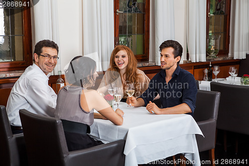 Image of Waiter happily accommodating couple