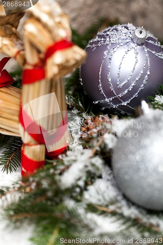 Image of Silver Christmas bauble on a tree with snow