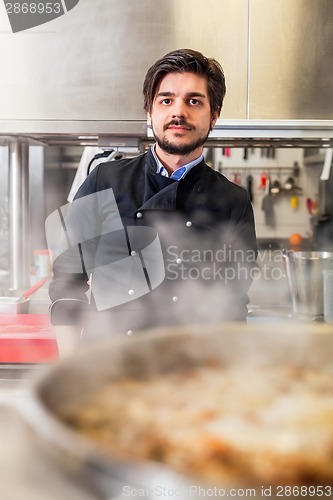 Image of Chef cooking a vegetables stir fry over a hob