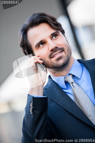 Image of Businessman listening to a call on his mobile