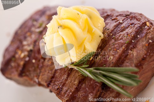 Image of Grilled beef steak topped with butter and rosemary