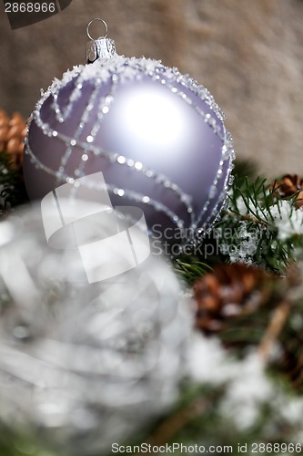 Image of Silver Christmas bauble on a tree with snow