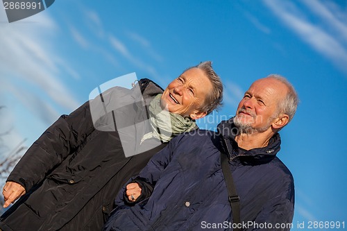 Image of happy elderly senior couple walking on beach