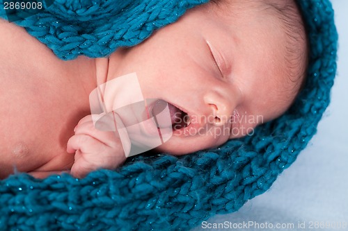 Image of Small infant wrapped in knitted fabric